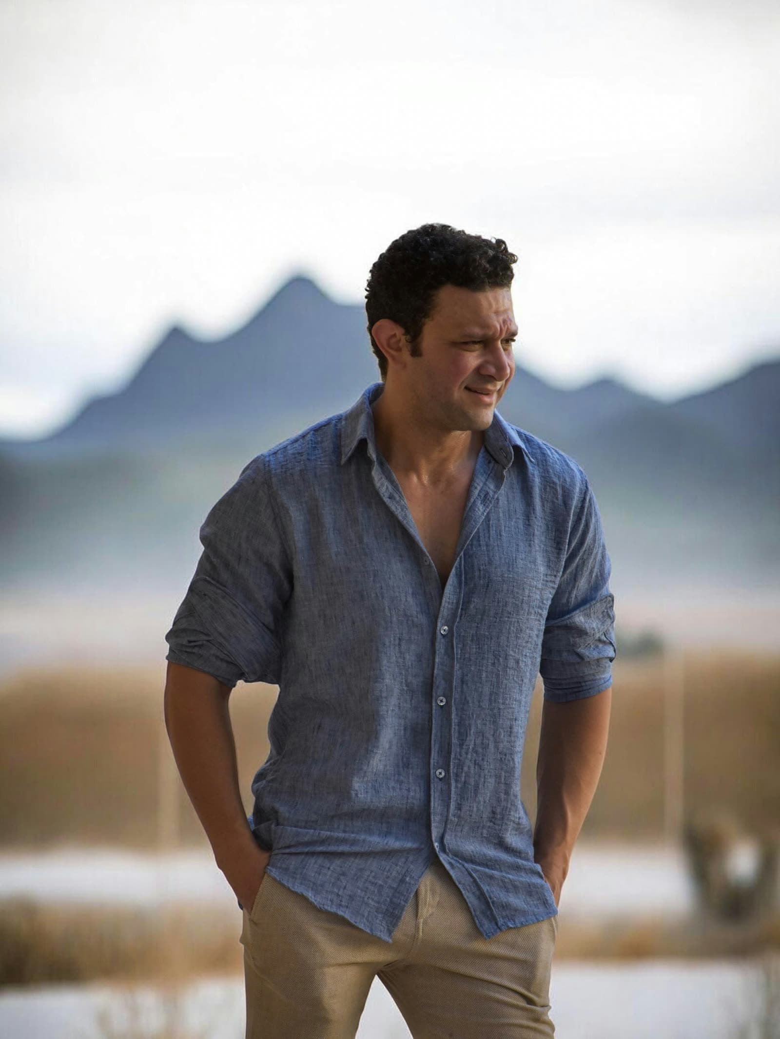 The navy linen shirt worn with the sleeves turned back, in open country under a flat sky